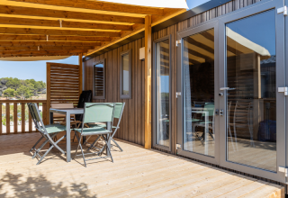 Udendørs terrasse med bord og stole på Premium Mobile Home med bakket beliggenhed på Les Tamaris.