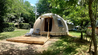 Dôme Wigwam au camping Ushuaïa Villages Le Viaduc en France, entouré d’arbres en pleine nature.