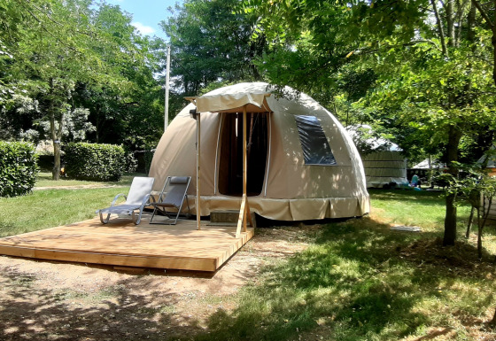 Wigwam dome at Campsite Ushuaïa Villages Le Viaduc in France, set among trees with a wooden deck.