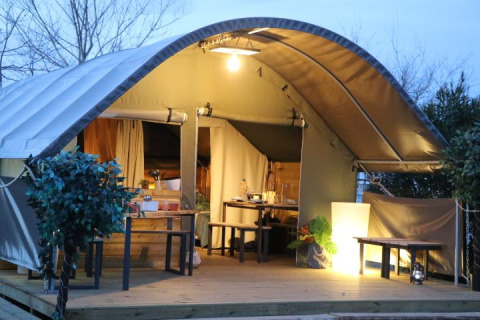 Oplyst safari telt ved Campsite Ushuaïa Villages Le Viaduc i Frankrig, med træterrasse og udendørs siddepladser.