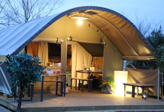 Oplyst safari telt ved Campsite Ushuaïa Villages Le Viaduc i Frankrig, med træterrasse og udendørs siddepladser.