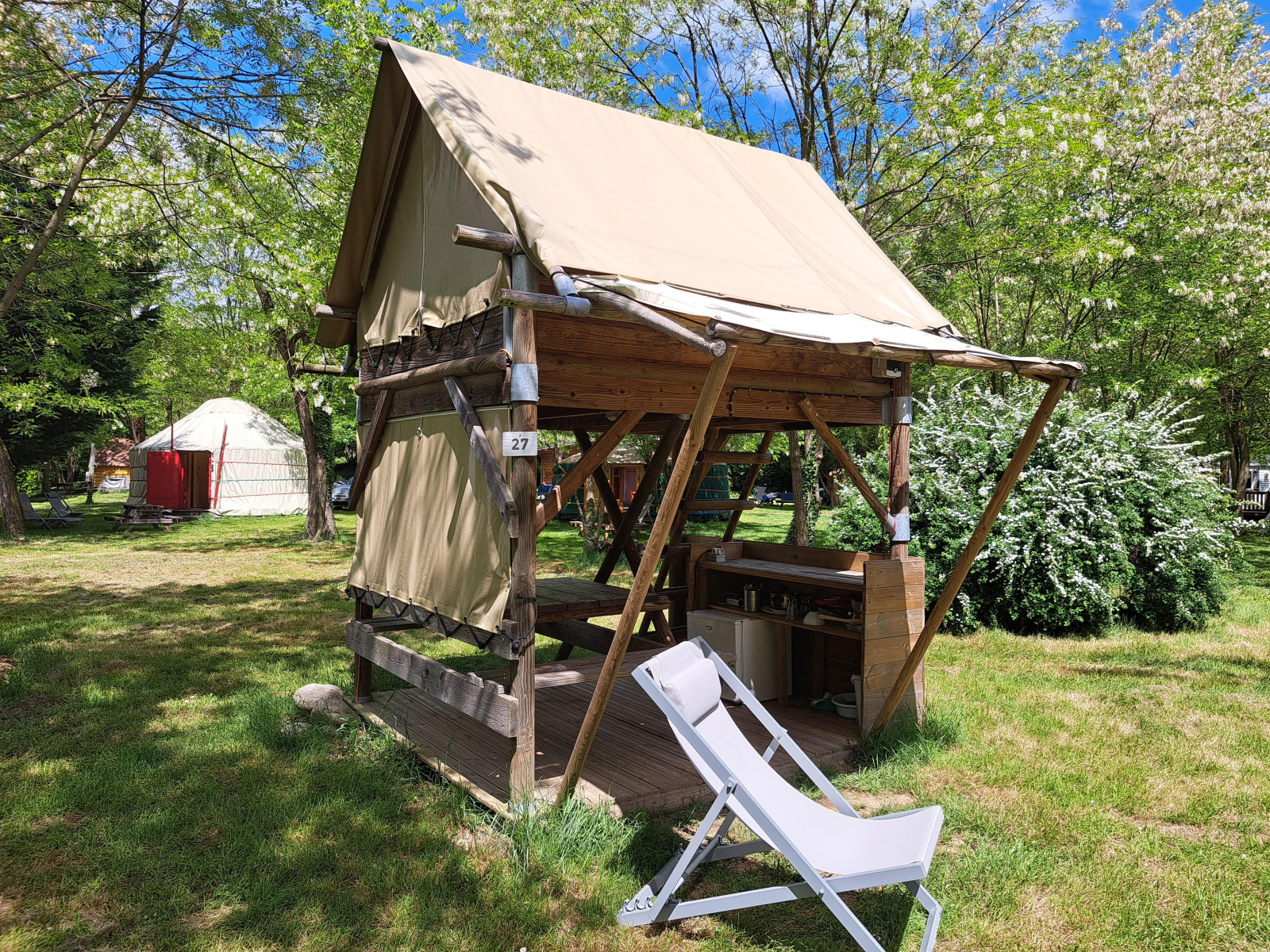 Bivak safaritent met open veranda en ligstoel op Campsite Ushuaïa Villages Le Viaduc in Frankrijk.