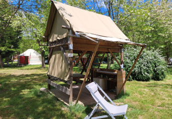 Bivouac safari telt med åben veranda og liggestol på Campsite Ushuaïa Villages Le Viaduc i Frankrig.
