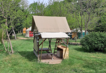 Tenda safari Bivouac al campeggio Ushuaïa Villages Le Viaduc in Francia, circondata da prato e alberi.