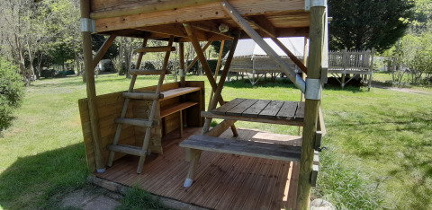 Houten terras en picknicktafel van de Bivouac-tent op Ushuaïa Villages Le Viaduc camping in Frankrijk.