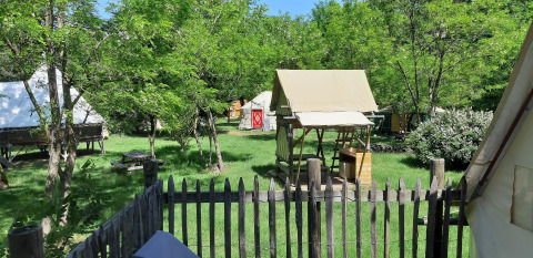Bivak-safaritent op Camping Ushuaïa Villages Le Viaduc in Frankrijk, omringd door gras en bomen.