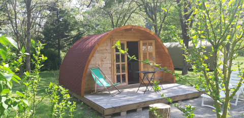 Pod in legno con terrazza e sedie a sdraio al campeggio Ushuaïa Villages Le Viaduc in Francia.