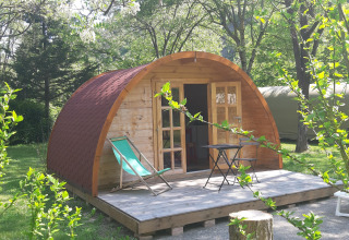 Pod in legno con terrazza e sedie a sdraio al campeggio Ushuaïa Villages Le Viaduc in Francia.
