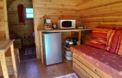 Interior of the 'Barrel' pod at Campsite Ushuaïa Villages Le Viaduc in France featuring a cozy kitchen area.