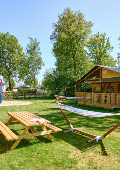 Grasveld met picknicktafel en speeltuin - Villatent - Recreatiepark De Lucht - Renswoude, Utrecht, Nederland