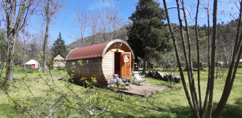 The 'Barrel' pod at Campsite Ushuaïa Villages Le Viaduc in France, set amid trees and grassy outdoors.