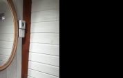 Round mirror and wooden wall paneling inside Tiny wagon cabin at Campsite Ushuaïa Villages Le Viaduc, France.