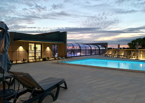 Outdoor swimming pool at sunset at Campsite La Nouvelle Croze, a holiday park in Nouvelle-Aquitaine, France.