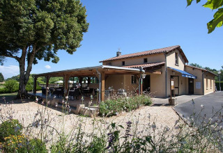 Photo of La Nouvelle Croze holiday park in Nouvelle-Aquitaine, France, featuring a terrace and lush greenery.