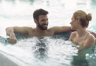 Una coppia sorridente si rilassa e trascorre un momento felice nella piscina del campeggio La Nouvelle Croze.