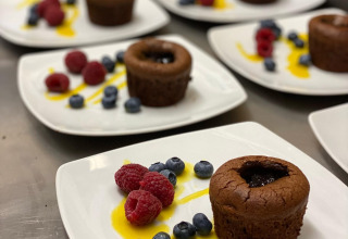 Tortini al cioccolato con lamponi e mirtilli freschi serviti su piatti bianchi pronti al ristorante.