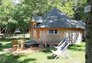 Finnish kota lodge at Campsite Ushuaïa Villages Le Viaduc in France with outdoor seating and greenery.