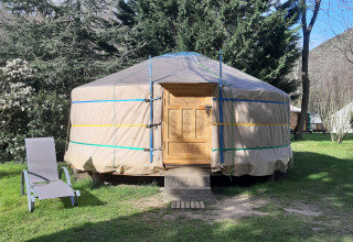 En traditionel yurt ved Campsite Ushuaïa Villages Le Viaduc i Frankrig med en stol i forhaven.