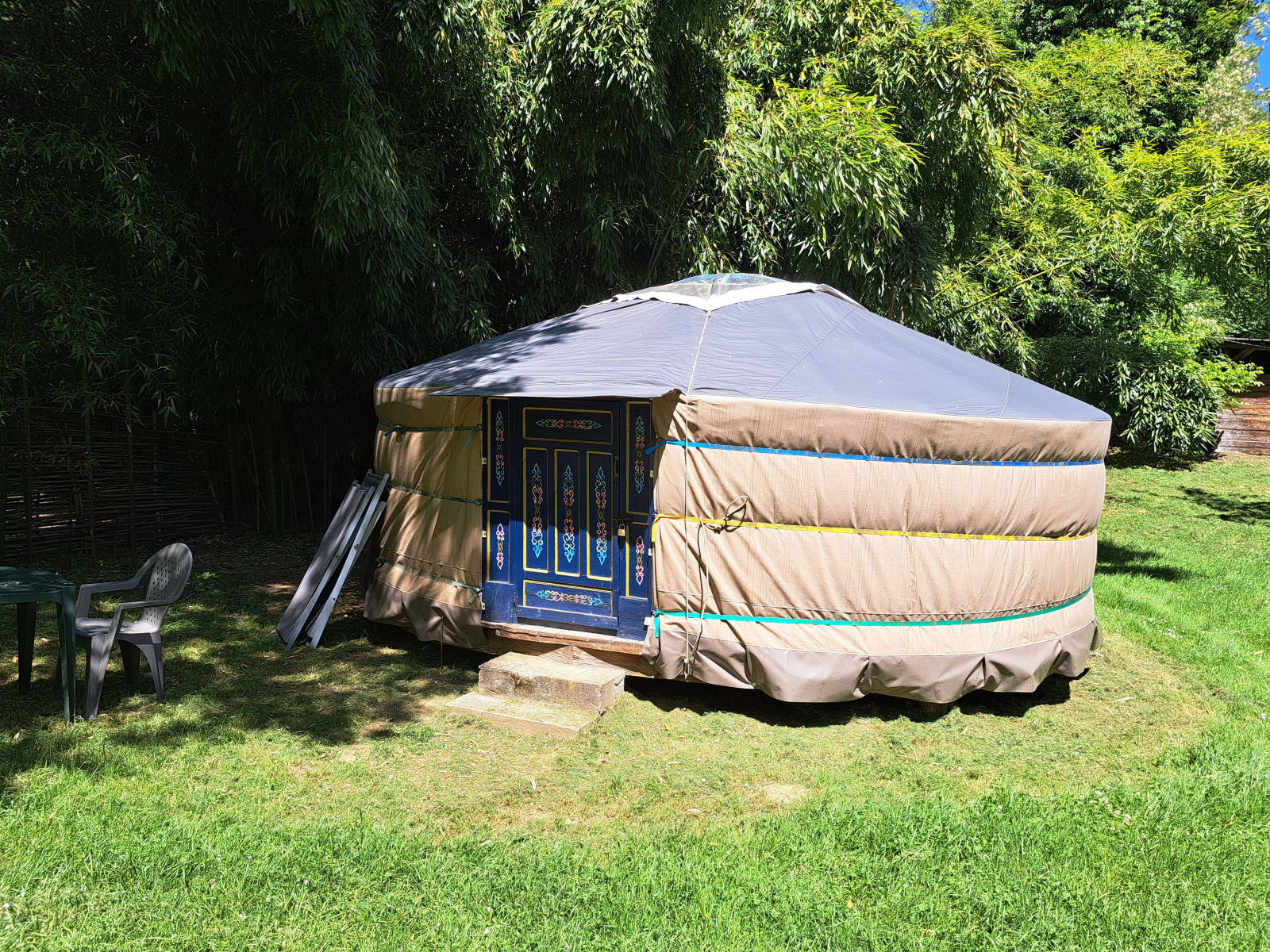 Een traditionele yurt op Campsite Ushuaïa Villages Le Viaduc in Frankrijk, omringd door groene natuur.