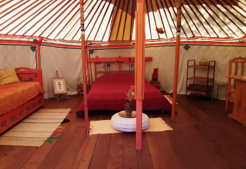 Interno di una yurta tradizionale con mobili in legno e letti presso Ushuaïa Villages Le Viaduc.