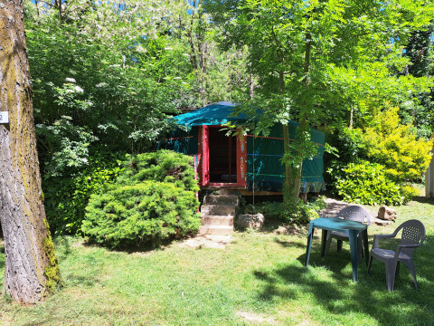 Yurta verde en Campsite Ushuaïa Villages Le Viaduc en Francia, rodeada de árboles y muebles de jardín.