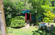 Yurta verde en Campsite Ushuaïa Villages Le Viaduc en Francia, rodeada de árboles y muebles de jardín.