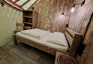 Houten interieur van de WOOD Yurt op Ushuaïa Villages Le Viaduc camping in Frankrijk, met bed.