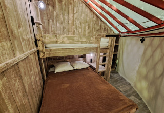 Interieur van de WOOD Yurt op Campsite Ushuaïa Villages Le Viaduc in Frankrijk met stapelbedden en hout.
