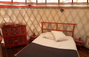 Dormitorio acogedor en una yurta con muebles de madera en el camping Ushuaïa Villages Le Viaduc en Francia.