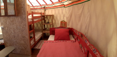 Interno di una yurta tradizionale con letto a castello e letto singolo a Ushuaïa Villages Le Viaduc in Francia.