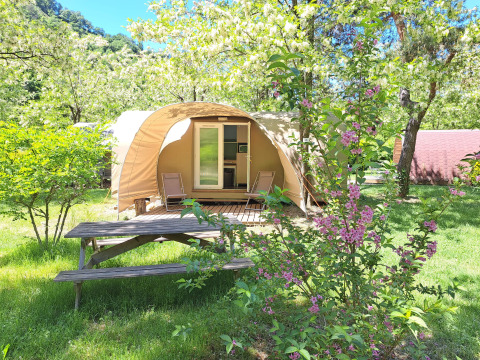Coco Sweet safari tent at Campsite Ushuaïa Villages Le Viaduc in France, surrounded by greenery and flowers.