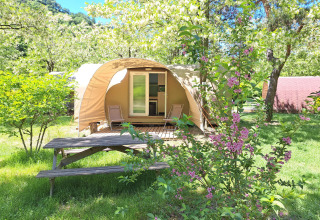 Tienda safari Coco Sweet en el camping Ushuaïa Villages Le Viaduc en Francia, rodeada de naturaleza y flores.