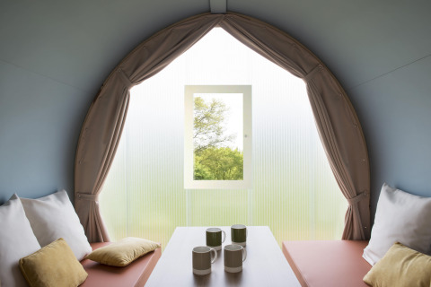Interior view from a Coco Sweet safari tent at Campsite Ushuaïa Villages Le Viaduc in France, with cushions.