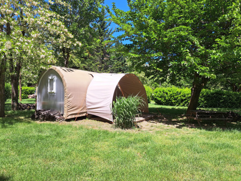 Coco Sweet safari tent at Ushuaïa Villages Le Viaduc campsite in France, surrounded by trees and greenery.