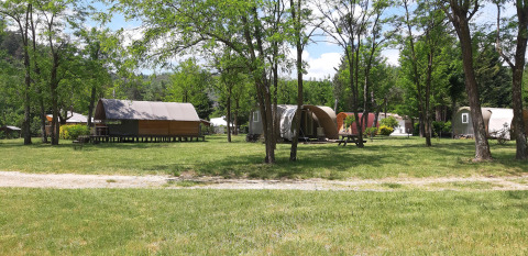 View of Coco Sweet safari tents at Campsite Ushuaïa Villages Le Viaduc, surrounded by trees and greenery.