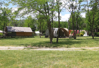 View of Coco Sweet safari tents at Campsite Ushuaïa Villages Le Viaduc, surrounded by trees and greenery.