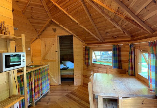 Interior view of a cozy wooden lodge named Finnish kota at Campsite Ushuaïa Villages Le Viaduc in France.