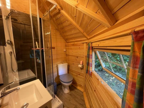 Holzbad im finnischen Kota bei Campsite Ushuaïa Villages Le Viaduc, Frankreich, mit Dusche und Fenster.