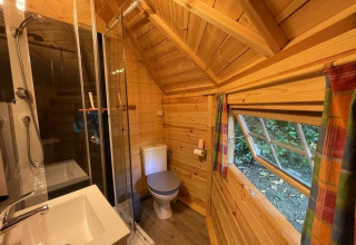 Holzbad im finnischen Kota bei Campsite Ushuaïa Villages Le Viaduc, Frankreich, mit Dusche und Fenster.