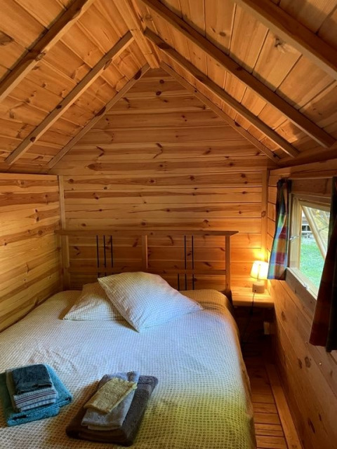Hyggelig træhytte med dobbeltseng, bløde puder og håndklæder i Finnish kota på Campsite Ushuaïa Villages Le Viaduc.