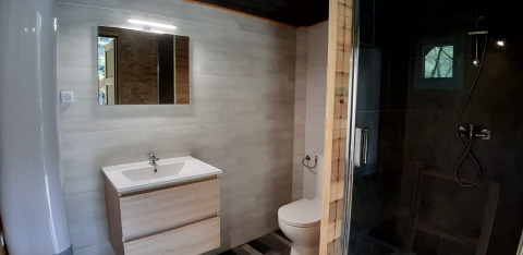 Bagno moderno in una casa sull'albero al campeggio Ushuaïa Villages Le Viaduc con doccia e lavabo.