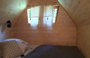 Chambre chaleureuse avec des murs en bois dans la Magic hut au Campsite Ushuaïa Villages Le Viaduc, France.