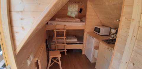 Interiør af Magic hut på Ushuaïa Villages Le Viaduc campingplads i Frankrig med køkken og køjesenge.