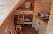Interior of Magic hut at Ushuaïa Villages Le Viaduc campsite in France with kitchenette and bunk beds.