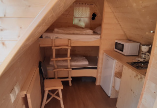 Interior of Magic hut at Ushuaïa Villages Le Viaduc campsite in France with kitchenette and bunk beds.