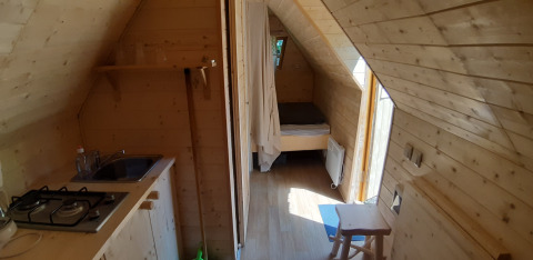 Interior view of the tiny wooden Magic hut at Campsite Ushuaïa Villages Le Viaduc in France.