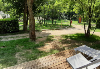 View from Magic hut at Campsite Ushuaïa Villages Le Viaduc, France, featuring trees and outdoor seating.