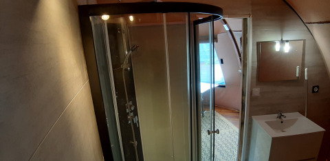 Salle de bain avec douche et lavabo dans le Wigwam Dome au Camping Ushuaïa Villages Le Viaduc, France.
