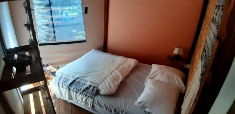 Gezellige slaapruimte binnenin de Wigwam dome op Campsite Ushuaïa Villages Le Viaduc, Frankrijk, met bed.
