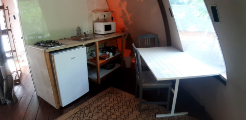 Zona de cocina dentro del domo Wigwam en Campsite Ushuaïa Villages Le Viaduc con mesa y ventana.